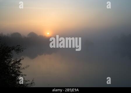 Ambiance sombre au coucher du soleil au-dessus d'une rivière misteuse Banque D'Images