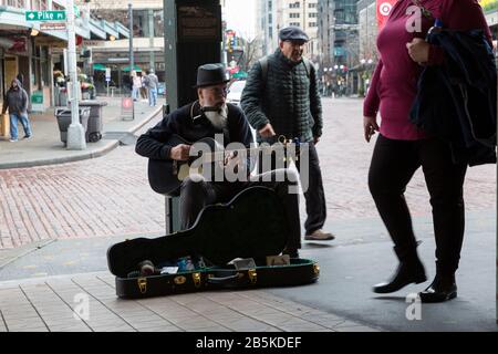 Un bustier divertit les touristes au marché de Pike Place pendant une matinée calme le dimanche 8 mars. 2020. Alors que l'épicentre de l'épidémie de coronavirus aux États-Unis, la lutte des entreprises de la région de Seattle pendant que les restrictions de travail et de voyage continuent d'avoir un impact sur l'économie locale. Banque D'Images