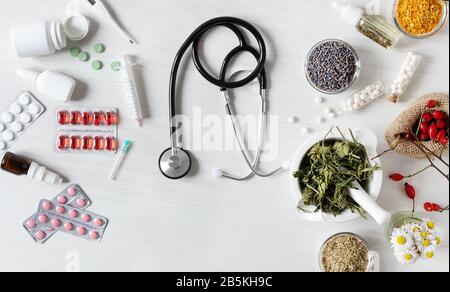 Médecine alternative VS médecine traditionnelle concept. Variété de traitements vue de dessus sur fond blanc en bois. Banque D'Images