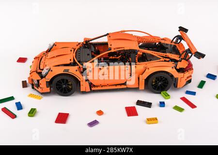 Différentes vues de la voiture LEGO Porsche GT 3 RS orange assemblée entourée de briques lego de rechange Banque D'Images