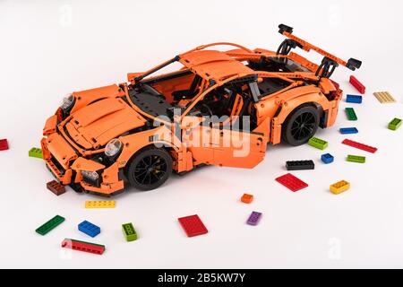 Différentes vues de la voiture LEGO Porsche GT 3 RS orange assemblée entourée de briques lego de rechange Banque D'Images