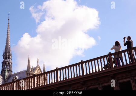 Couple avec buggy prenant des photos de la cathédrale notre Dame depuis le pont, Paris Banque D'Images