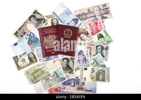 L'est rencontre le concept de voyage du monde occidental avec l'Union européenne britannique et les passeports chinois, ainsi qu'un mélange de devises occidentales et asiatiques Banque D'Images