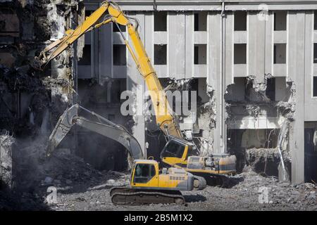 Construction de l'ancien hôtel démolition pour la nouvelle construction, à l'aide d'une pelle hydraulique spéciale-destroyer. Démolition complète hautement mécanisée Banque D'Images