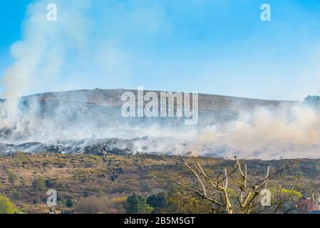 Les pompiers qui s'attaquent au feu sur Ilkley Moor, dans le West Yorkshire, dans la soirée du 20 avril 2019, après une journée exceptionnellement chaude. Banque D'Images