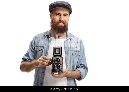 Homme barbu tenant un appareil photo à l'ancienne et souriant isolé sur fond blanc Banque D'Images