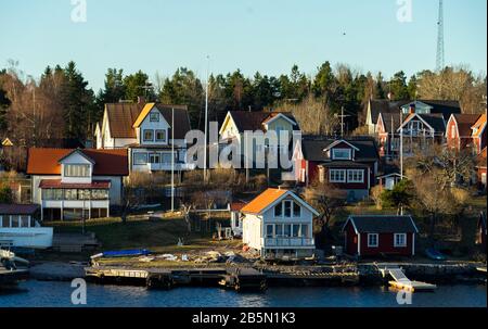 Des maisons d'été pittoresques peintes en rouge falun traditionnel sur l'île de l'archipel de Stockholm dans la mer Baltique en début de matinée. Banque D'Images