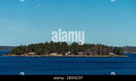 Des maisons d'été pittoresques peintes en rouge falun traditionnel sur l'île de l'archipel de Stockholm dans la mer Baltique en début de matinée. Banque D'Images