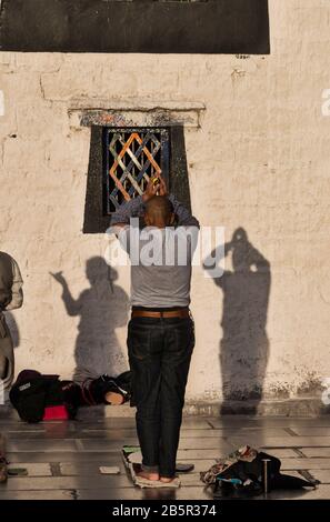 Le croyant bouddhiste prie devant le Jokhang, le temple le plus sacré du Tibet, Lhasa Banque D'Images