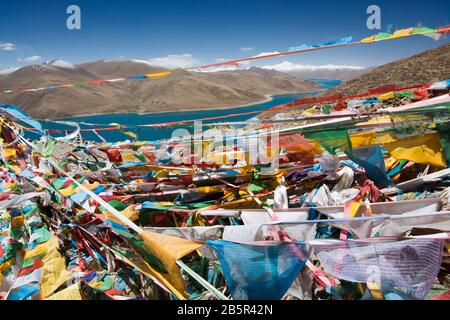 Drapeaux de prière sur le lac Yamdrok, un des lacs holly du Tibet Banque D'Images