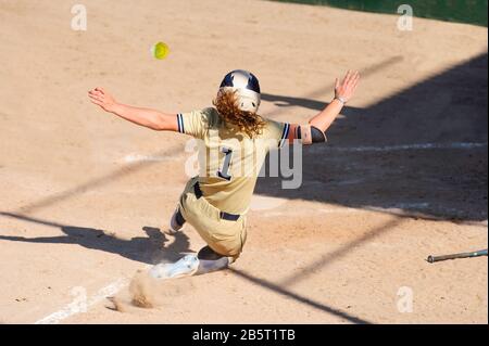 Un joueur de baseball Glisse Dans la base de maison Pendant que le ballon est en vol À Travers l'air Banque D'Images