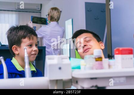 Deux jeunes frères heureux assis dans un bureau de dentiste et attendant un examen dentaire Banque D'Images