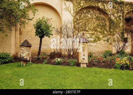 Les arnaques sculptées protègent le lit de fleurs dans les jardins de Vojan, un parc urbain serein avec des sentiers de randonnée de paons, des pelouses vertes, des jardins et des arbres fruitiers Banque D'Images