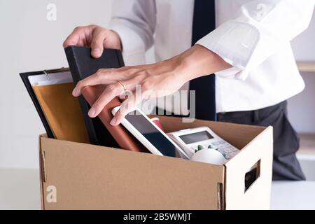 Les jeunes hommes d'affaires tristes Ont Tiré des boîtes, y compris une usine de pot et des documents pour le chômage des biens personnels, concept résigné Banque D'Images