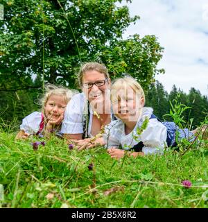Mère avec filles posant sur pré dans la nature printanière Banque D'Images