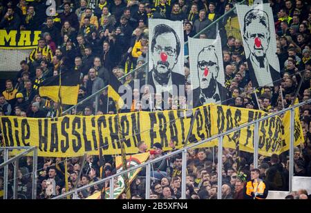 Protestation dans le bloc DE FAN DE DO avec une bannière "les visages laides du football" et les visages de Dietmar HOPP (Maezen, 1899), et Fritz KELLER (GER, président du DFB) avec nez rouge clown, football 1. Bundesliga, 25ème jour de jumelage, Borussia Monchengladbach (MG) - Borussia Dortmund (DO), le 7 mars 2020 en Borussia Monchengladbach/Allemagne. | utilisation dans le monde entier Banque D'Images