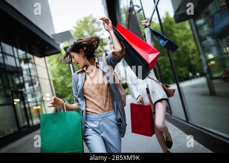 Belles jeunes femmes avec des sacs de shopping on city street Banque D'Images