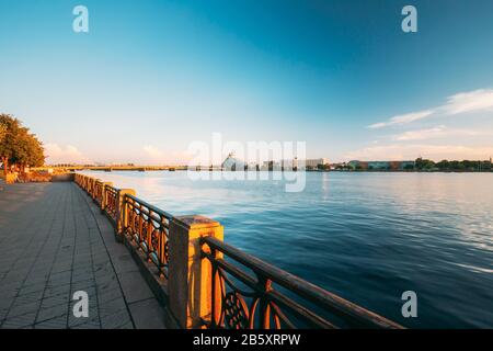 Riga, Lettonie.Promenade De La Ville Près De La Rivière Daugava, Du Bâtiment De La Bibliothèque Nationale Et De L'Hôtel Radisson Blu À La Jetée Pittoresque Embankment Sous Le Ciel Bleu Au Coucher Du Soleil E. Banque D'Images