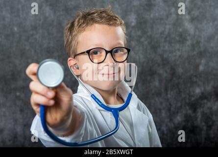 Mignon enfant garçon porter uniforme de médecine jouant médecin, un portrait Banque D'Images