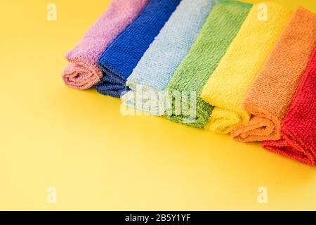 Serviettes en microfibre colorées, sur fond jaune.chiffon en microfibre de nettoyage isolé, plié serviettes en textile de nettoyage pile colorée. Domestique Banque D'Images