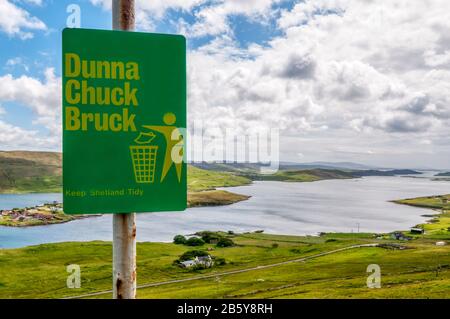 Le dialecte Shetland Dunna Chuck Bruck signe sur Mainland Shetland avec Weisdale Voe en arrière-plan. Il se traduit comme ne pas jeter les ordures. Banque D'Images