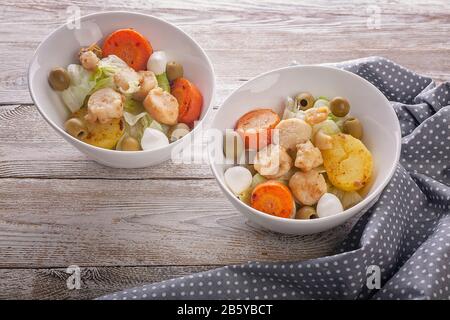 Salade de pétoncles, légumes, fromage mozzarella et olives sur une table rustique en bois. Délicieux fruits de mer Banque D'Images