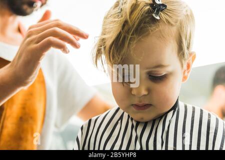 Un petit garçon dans un salon de coiffure Banque D'Images