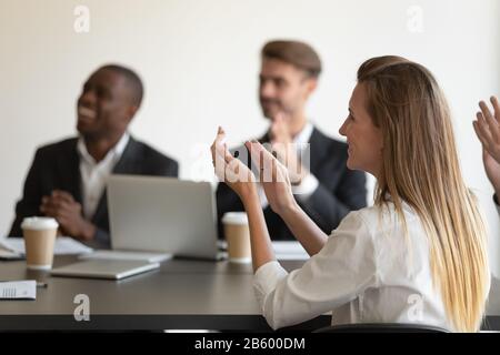 Vue latérale jeune femme souriante applaudissant à l'orateur. Banque D'Images