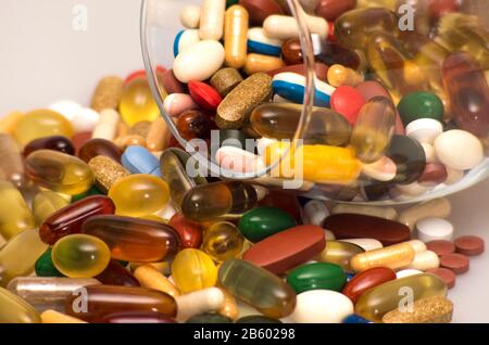 pilules colorées qui débordent de verre. concept de pharmacie de médecine Banque D'Images
