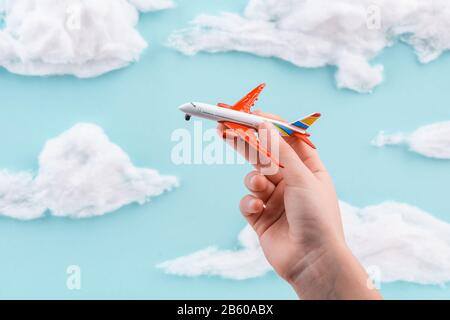 Enfant jouant avec un avion jouet sur le ciel bleu fait à la main Banque D'Images