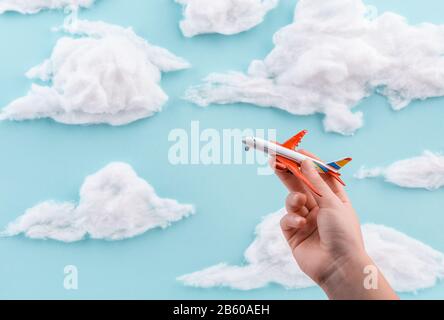 Jouet avion dans la main d'un enfant voler à travers le ciel Banque D'Images