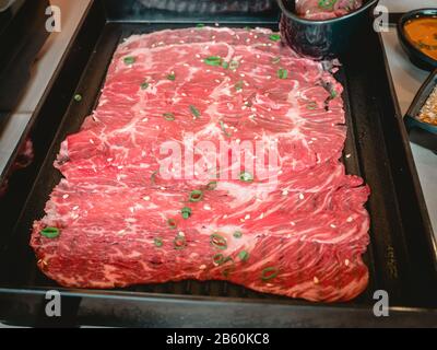 Tranches de bœuf de pari avec sauce ponzu dans une plaque en céramique noire sur la table du japon au restaurant. Banque D'Images