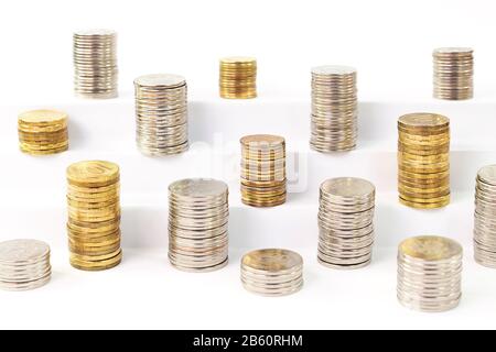 Piles de pièces de monnaie en métal sur un escalier blanc Banque D'Images