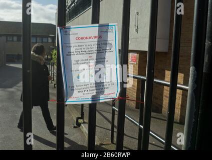 Les visiteurs marchent après les panneaux d'avertissement de Coronavirus à l'hôpital NHS de Homerton à Londres, en Angleterre, au Royaume-Uni Banque D'Images