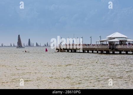 De Brisbane à Gladstone, la course de yacht part de Shorncliffe chaque année à l'heure de pâques. Les gens se sont mis sur la jetée pour regarder le début de la course. Banque D'Images