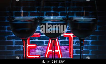 Jeu de trois verres à vin Trensperent sur fond avec du texte MANGER, bannière Banque D'Images