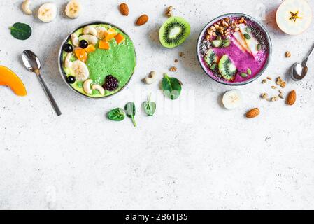 Smoothie Bowls colorés pour un petit-déjeuner sain, vue de dessus, espace de copie. Bols à smoothie aux épinards et aux baies verts avec divers garnitures. Mousse végétalienne brute Banque D'Images