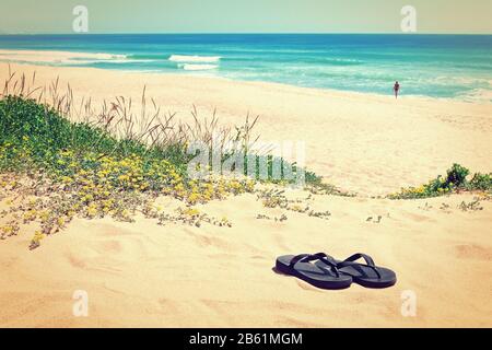 Chaussons sur le fond de la belle plage et de la mer. Dans les couleurs chaudes. Banque D'Images