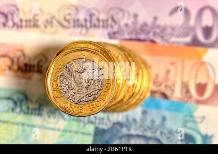 Pile de pièces de monnaie en livre britannique sur les billets de banque Banque D'Images
