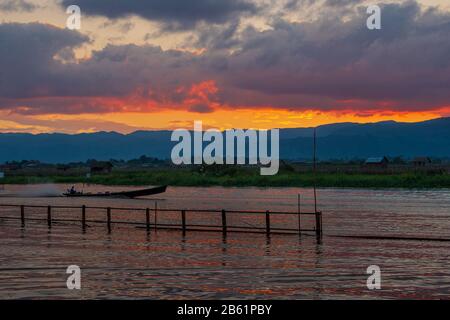 Bateau motorisé traversant les canaux du lac Inle après le coucher du soleil Banque D'Images