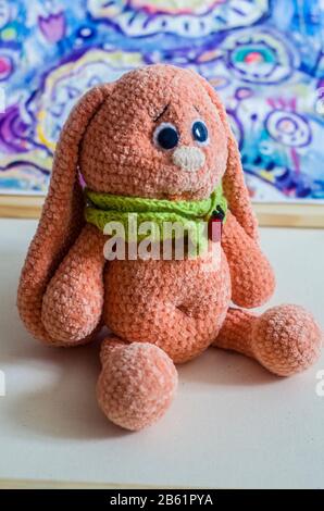 Tricoté lapin jouet abricot couleur sur un arrière-plan pittoresque. Photo de Pâques. Banque D'Images