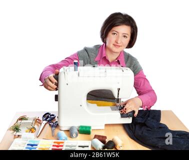 Femme d'âge moyen travaillant dans une usine de vêtements. Sur fond blanc. Banque D'Images