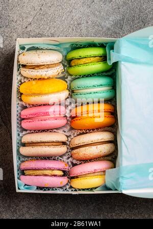 Macarons multicolores aux goûts différents dans une boîte cadeau Banque D'Images