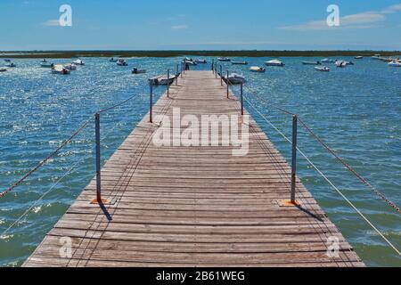 Pont en bois dans le port en mer contre les bateaux. Banque D'Images