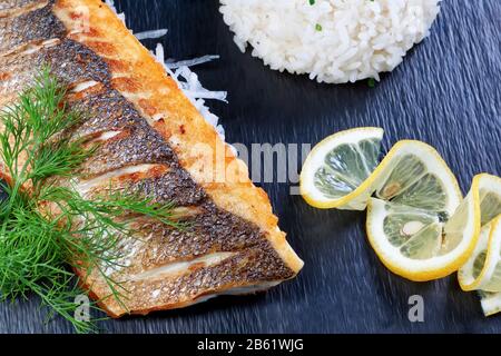 Magnifique délicieux morceau de poisson sur fond de légumes verts et de riz. Plats à sushi. Banque D'Images