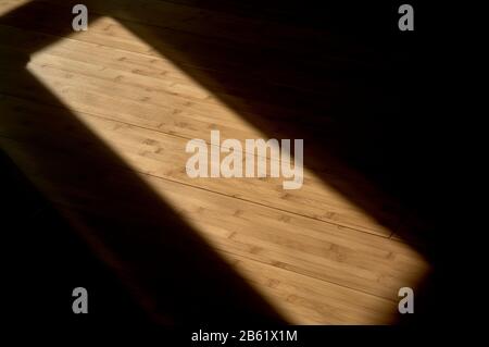 détail de la projection de la lumière du soleil lors de la pose d'une vitre et de la réflexion sur un plancher en bois Banque D'Images