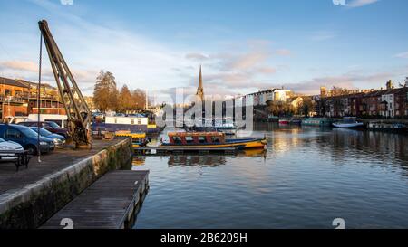 Bristol, Angleterre, Royaume-Uni - 29 décembre 2019 : le soleil du soir brille sur la flèche de l'église St Mary Redcliffe et les quais historiques de Bristol. Banque D'Images