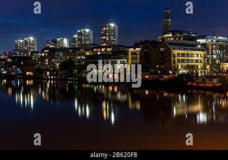 Des bateaux et des immeubles résidentiels bordent le front de rivière Thames à Brentford au crépuscule, avec la station De Pompage du pont Kew et la Maison du Conseil du Dragon Vert Banque D'Images