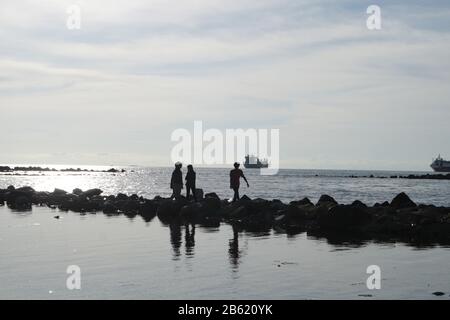 Makassar, Sulawesi Du Sud, Indonésie. 9 mars 2020. Un certain nombre d'adolescents ont marché sur des rochers au bord de la plage de Losari, dans la ville de Makassar, dans la province de Sulawesi Sud. Crédit: Herwin Bahar/Zuma Wire/Alay Live News Banque D'Images