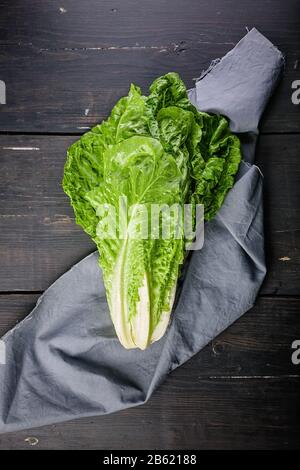 Salade de romano vert vif sur une serviette grise sur fond en bois sombre. Éclairage des touches de fonction Banque D'Images